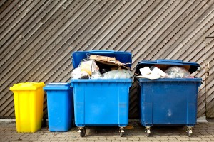 overfilled trash of large wheelie bins for rubbish, recycling an