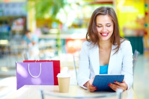Shopping girl laughing looking at the screen of her portable dev