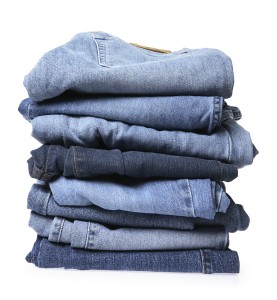 Stack of blue jeans on white background